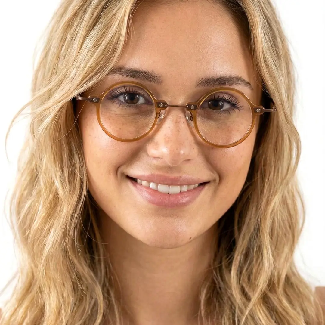 Front view of female wearing steampunk gold round eyeglasses, smiling, RA0092309