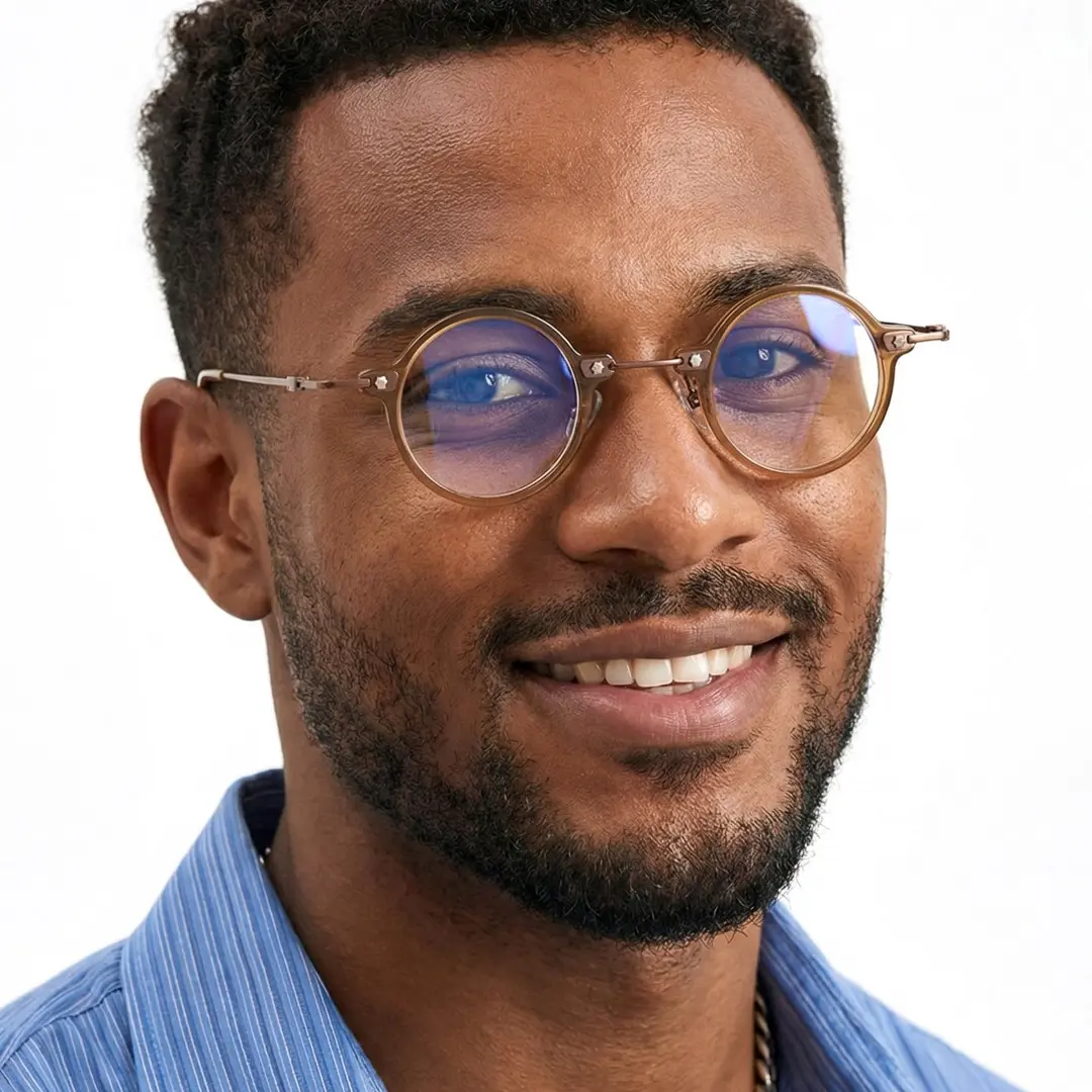 Three-quarter view of male wearing steampunk gold round eyeglasses, smiling, RA0092309