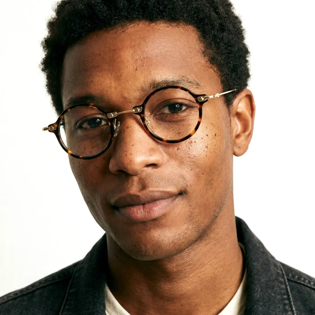 Front view of male wearing steampunk tortoise round eyeglasses, natural smile, RA0092309