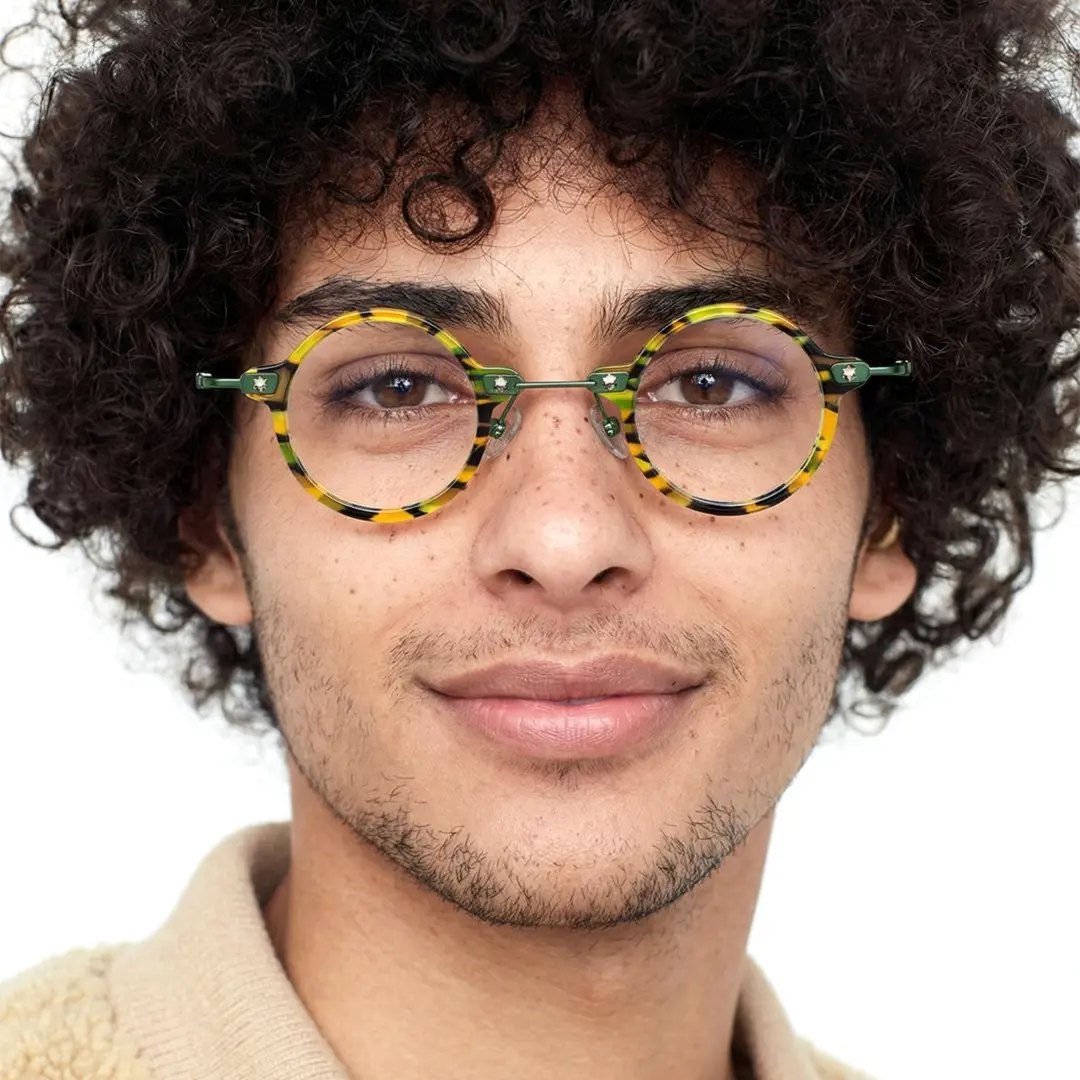 Front view of male wearing yellow tortoise round eyeglasses, smiling, RA0092309