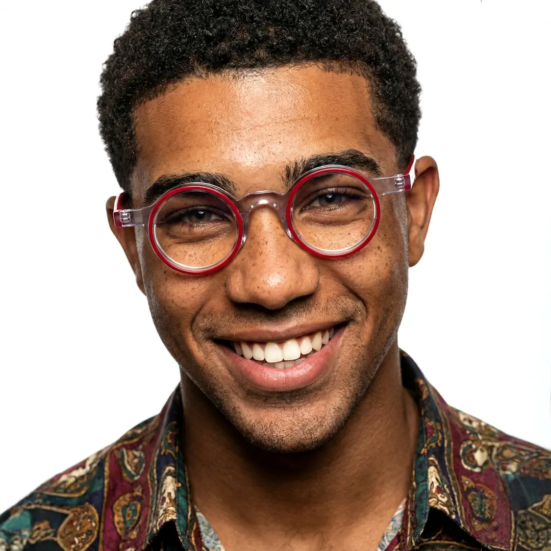 Front view of male wearing red round eyeglasses, smiling, RA0162406