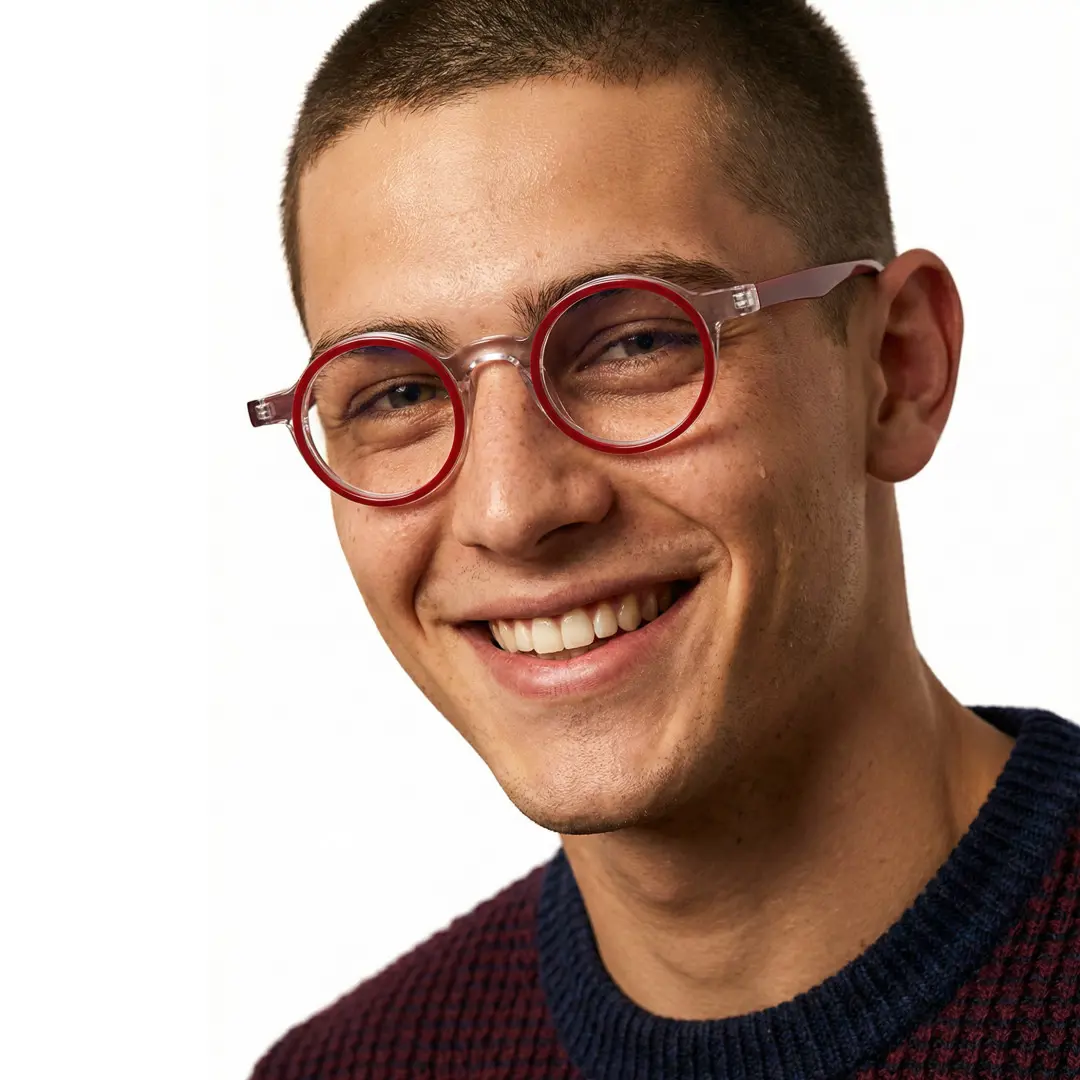 Three-quarter view of male wearing red round eyeglasses, smiling, RA0162406