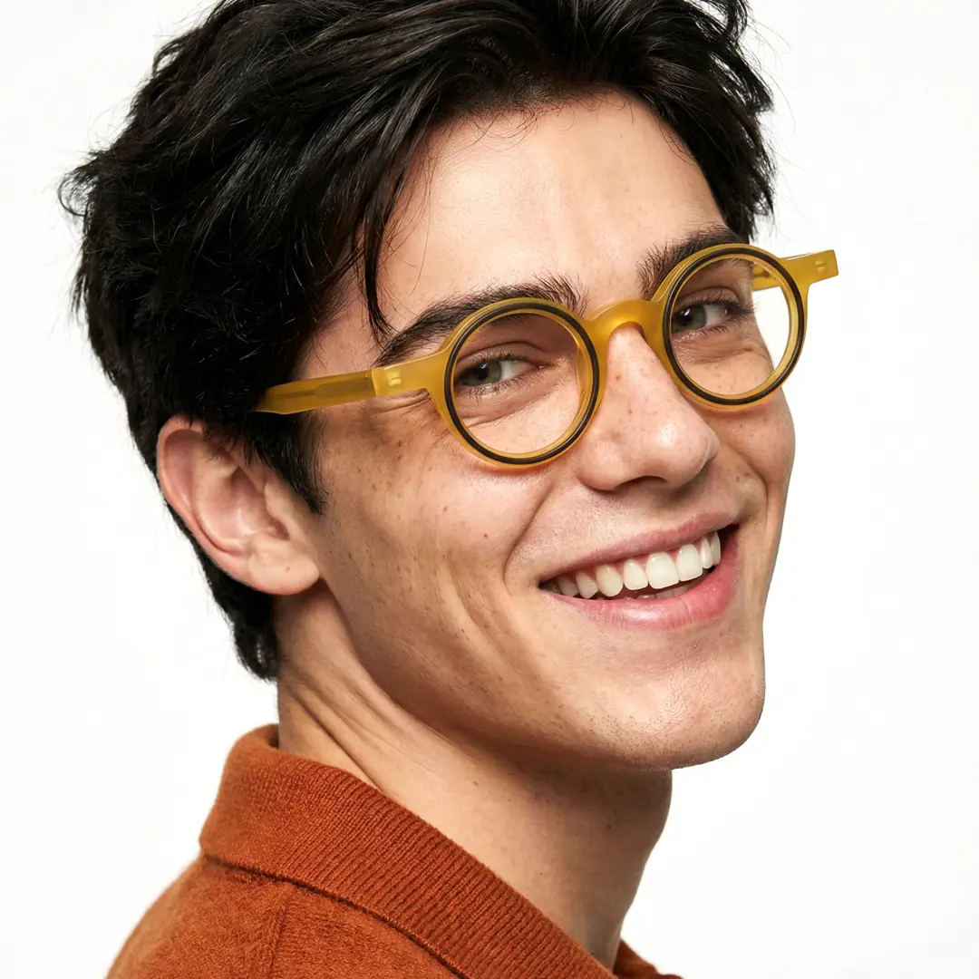 Over-the-shoulder view of male wearing yellow round eyeglasses, smiling, RA0162406