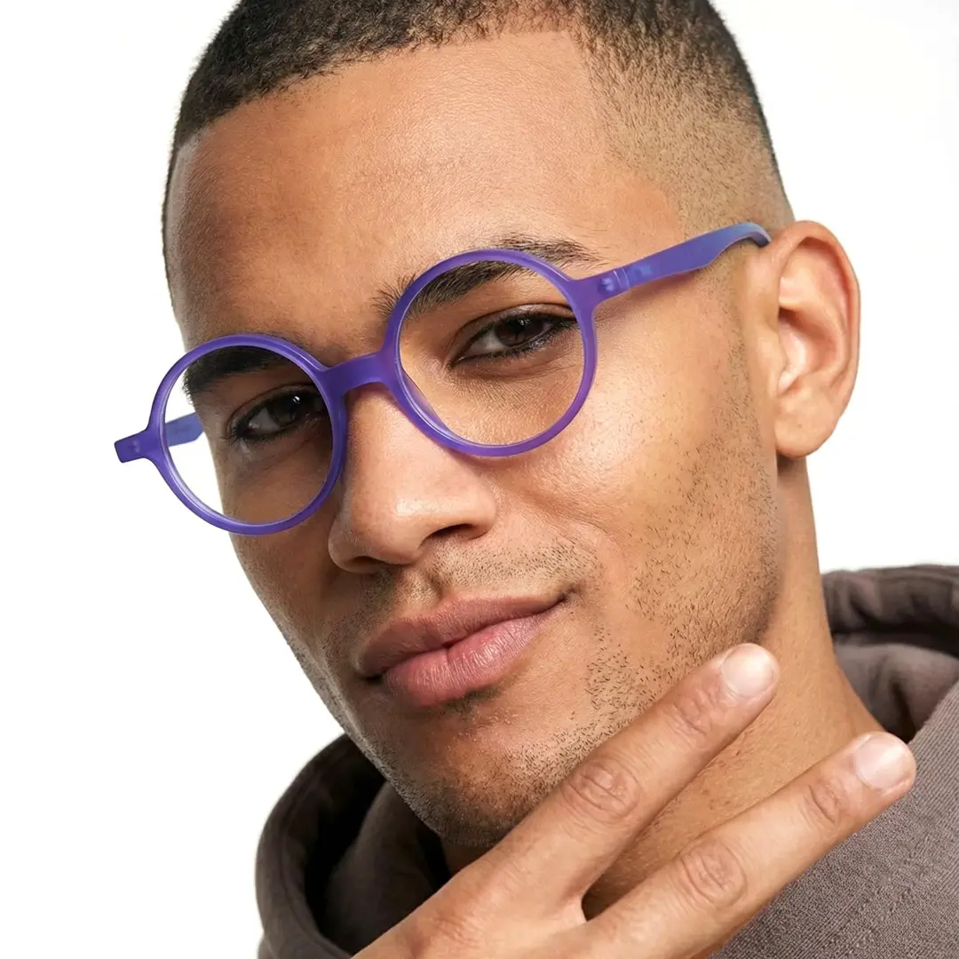 Profile view of male wearing purple round eyeglasses, soft smile, RA0222310
