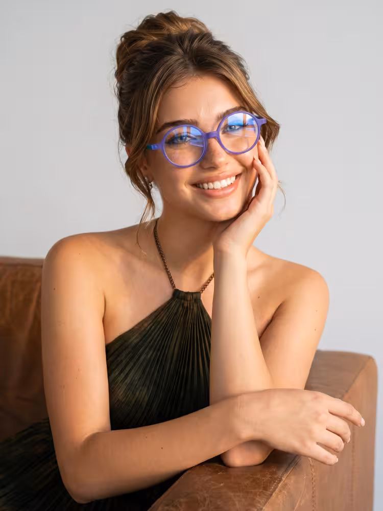 Female model wearing colorful purple round acetate eyeglasses in a studio setting. SPU: RA0222310