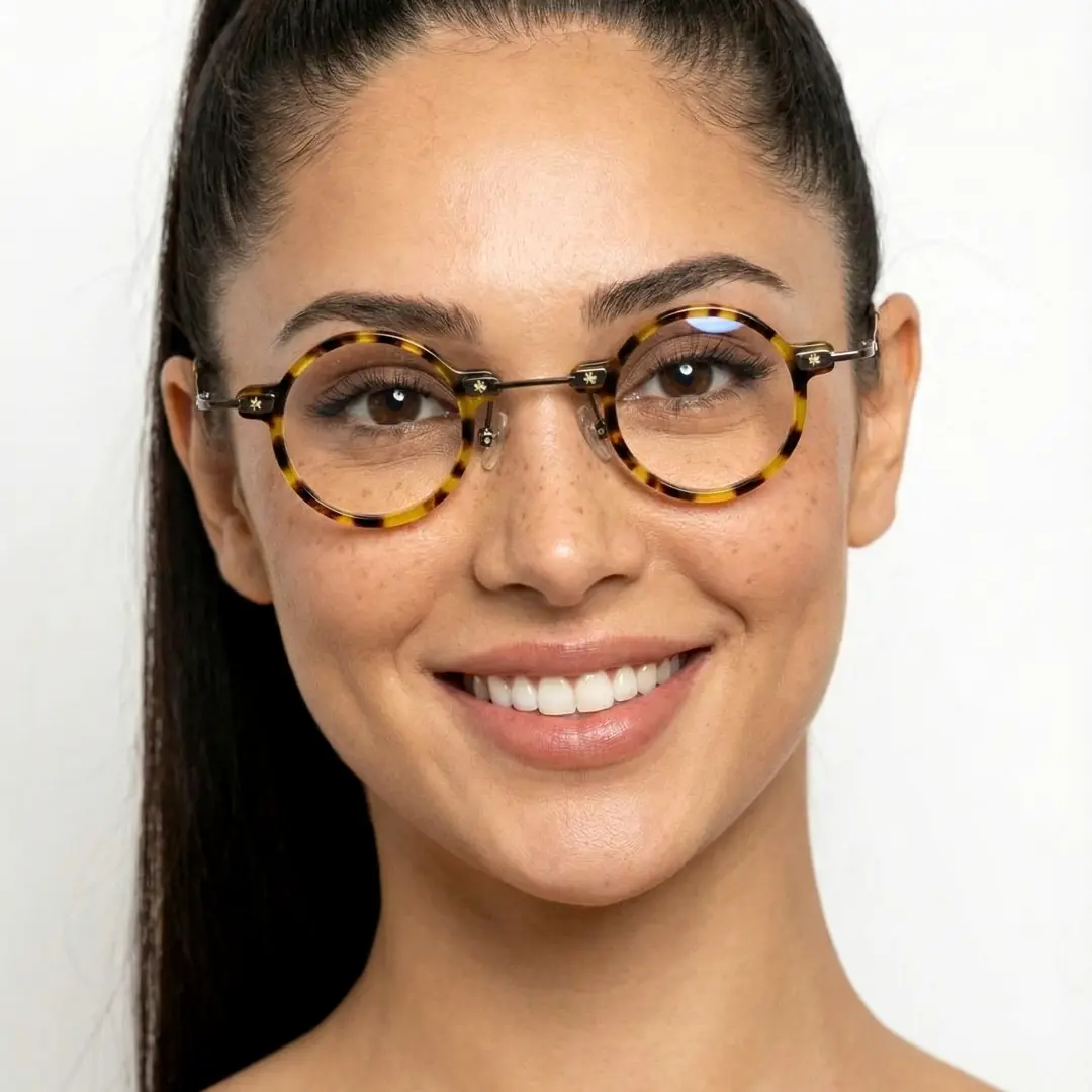 Front view of female wearing steampunk yellow tortoise round eyeglasses, smiling, RA0282411