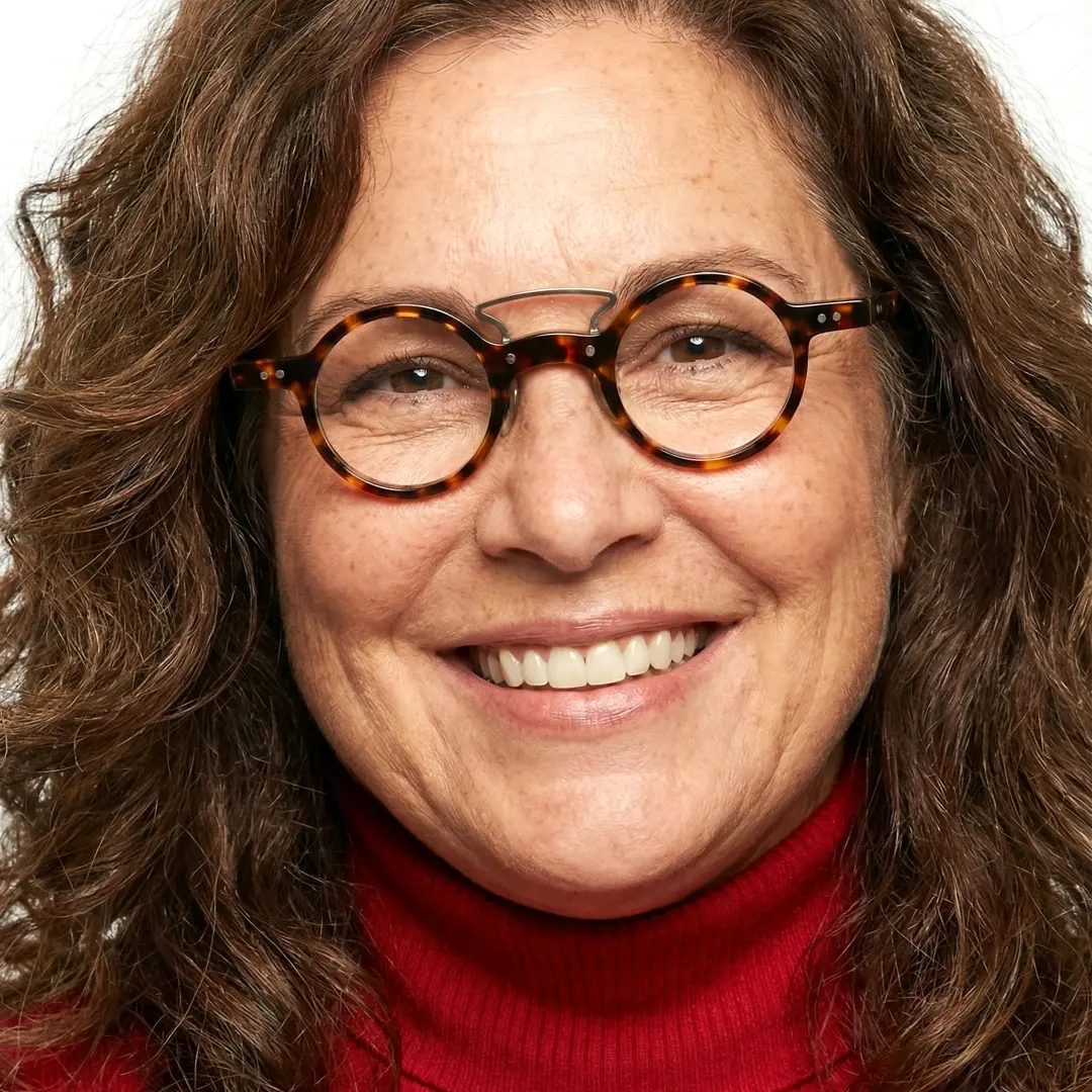 Face close-up view of female wearing vintage tortoise round eyeglasses, smiling, RA0302310
