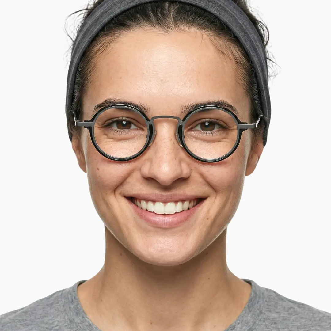 Front view of female wearing silver round eyeglasses, smiling, RA0302402