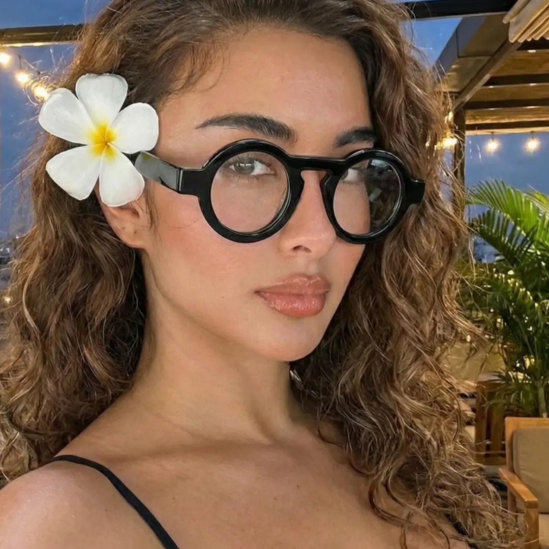 Profile view of female wearing black round eyeglasses, natural smile, RA0312411