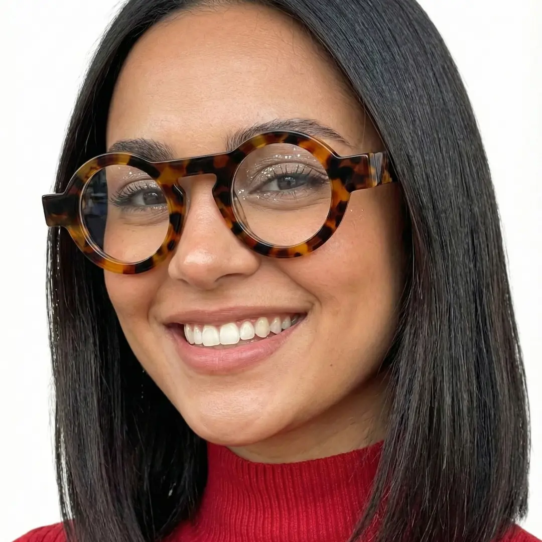 Slightly angled view of female wearing tortoise round eyeglasses, smiling, RA0312411