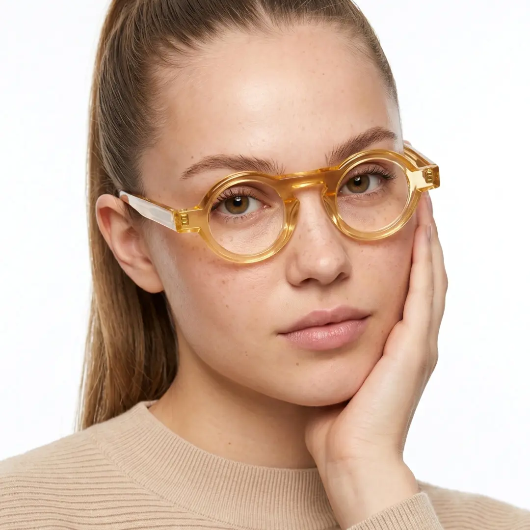 Front view of female wearing yellow round eyeglasses, hand near face, neutral expression, RA0312411