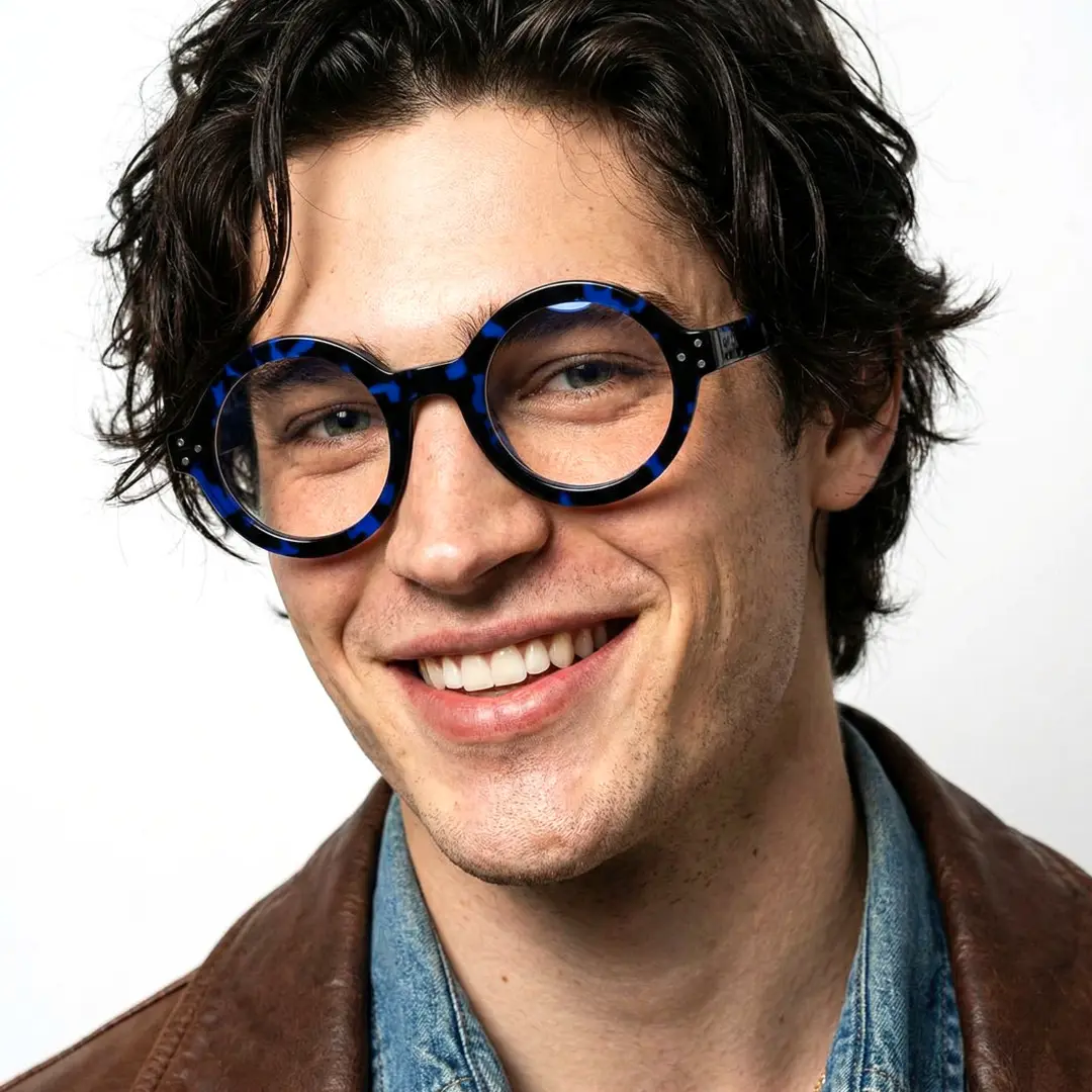 Front view of male wearing blue round eyeglasses, smiling, RA0322408