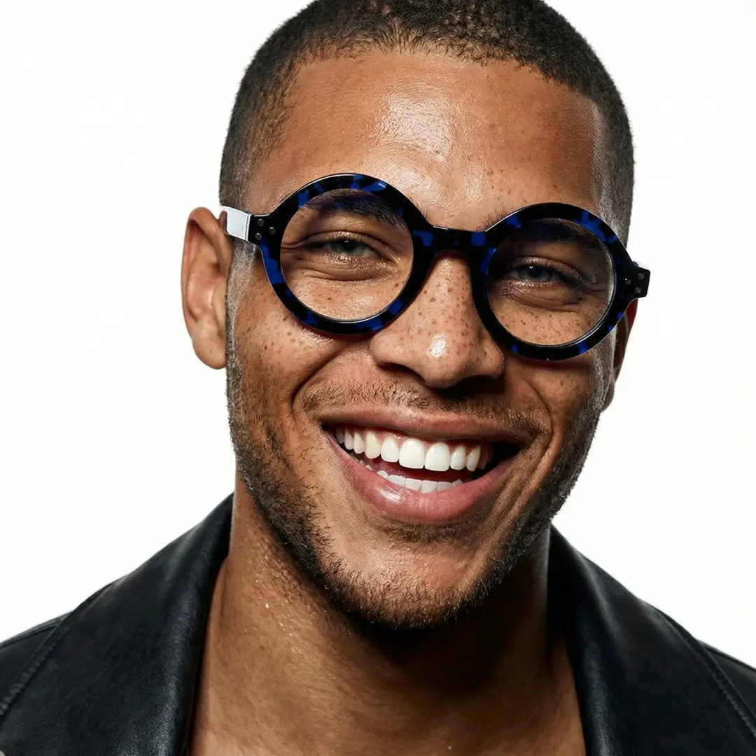 Front view of male wearing blue round eyeglasses, soft smile, RA0322408