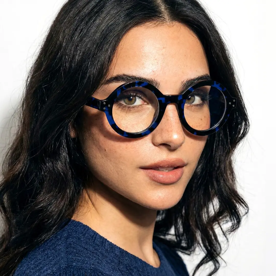 Over-the-shoulder view of female wearing blue round eyeglasses, relaxed expression, RA0322408