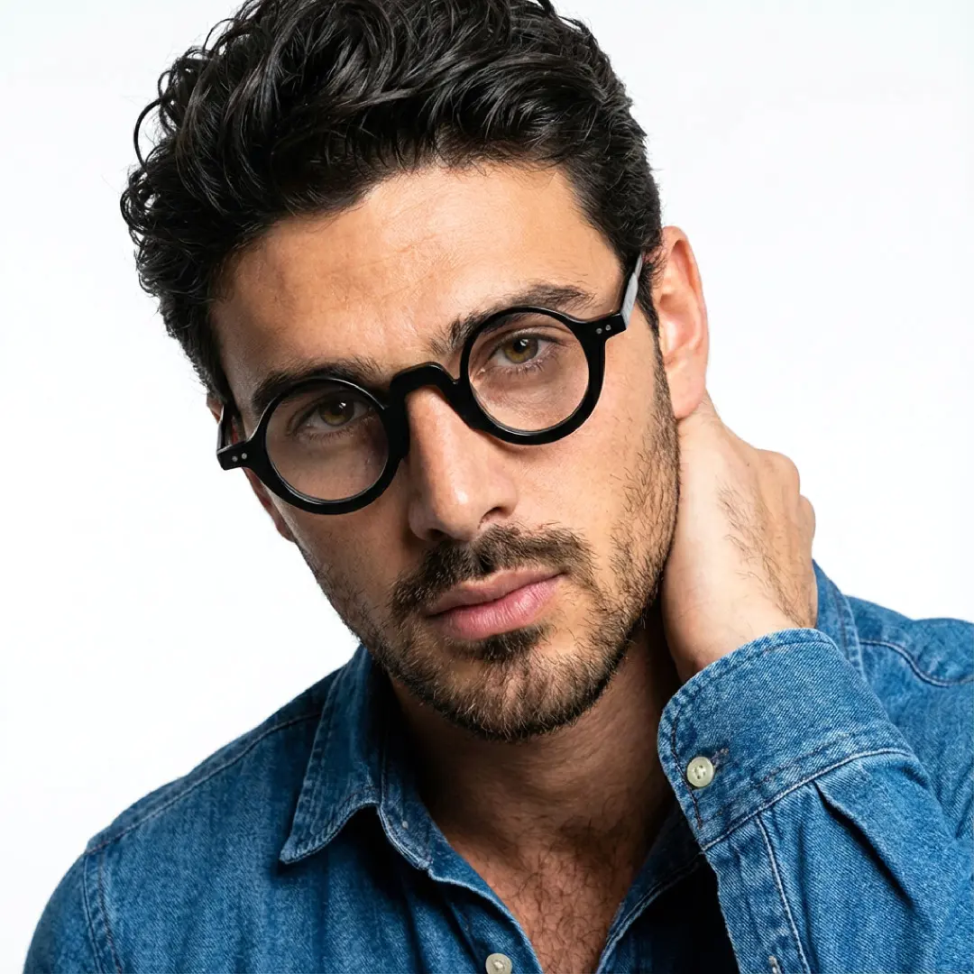 Front view of male wearing vintage black round eyeglasses, hand touching shoulder, calm expression, RA0322504