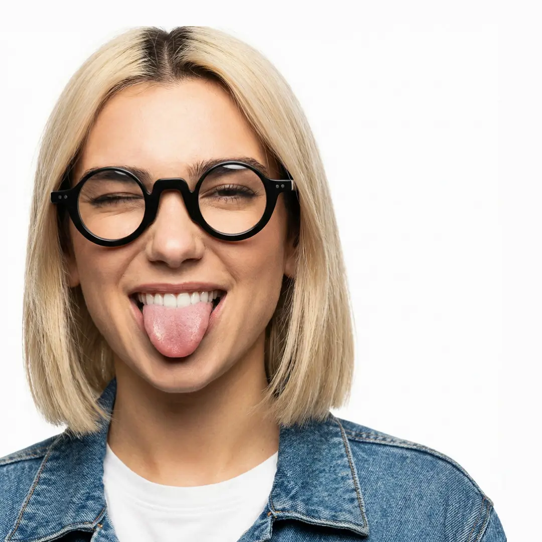 Front view of female wearing vintage black round eyeglasses, sticking out tongue, relaxed expression, RA0322504