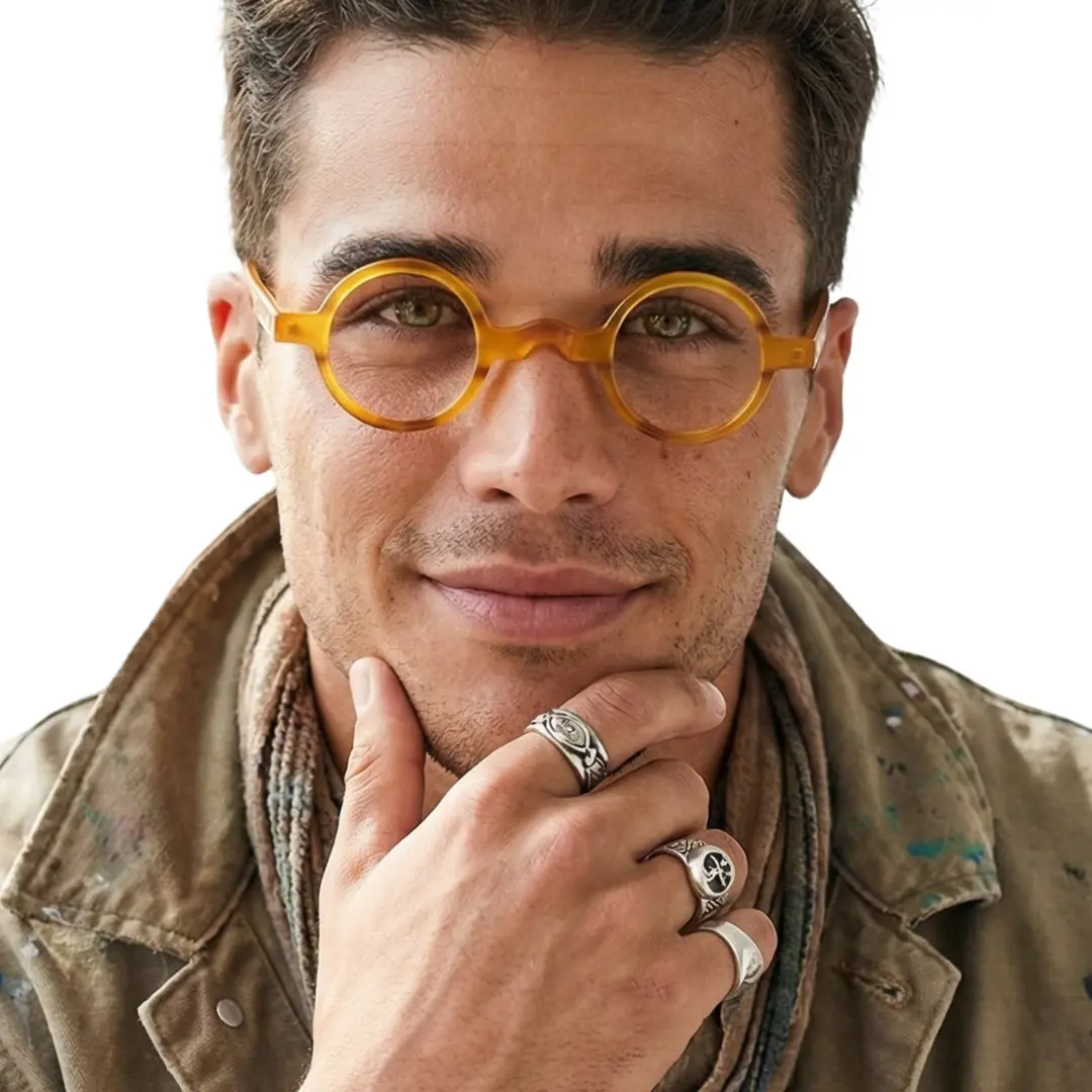 Front view of male wearing vintage orange round eyeglasses, resting chin on hand, friendly smile, RA0332507