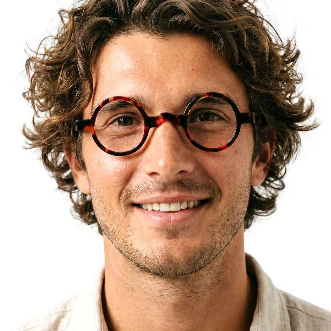 Front view of male wearing tortoise round eyeglasses, natural smile, RA0332507