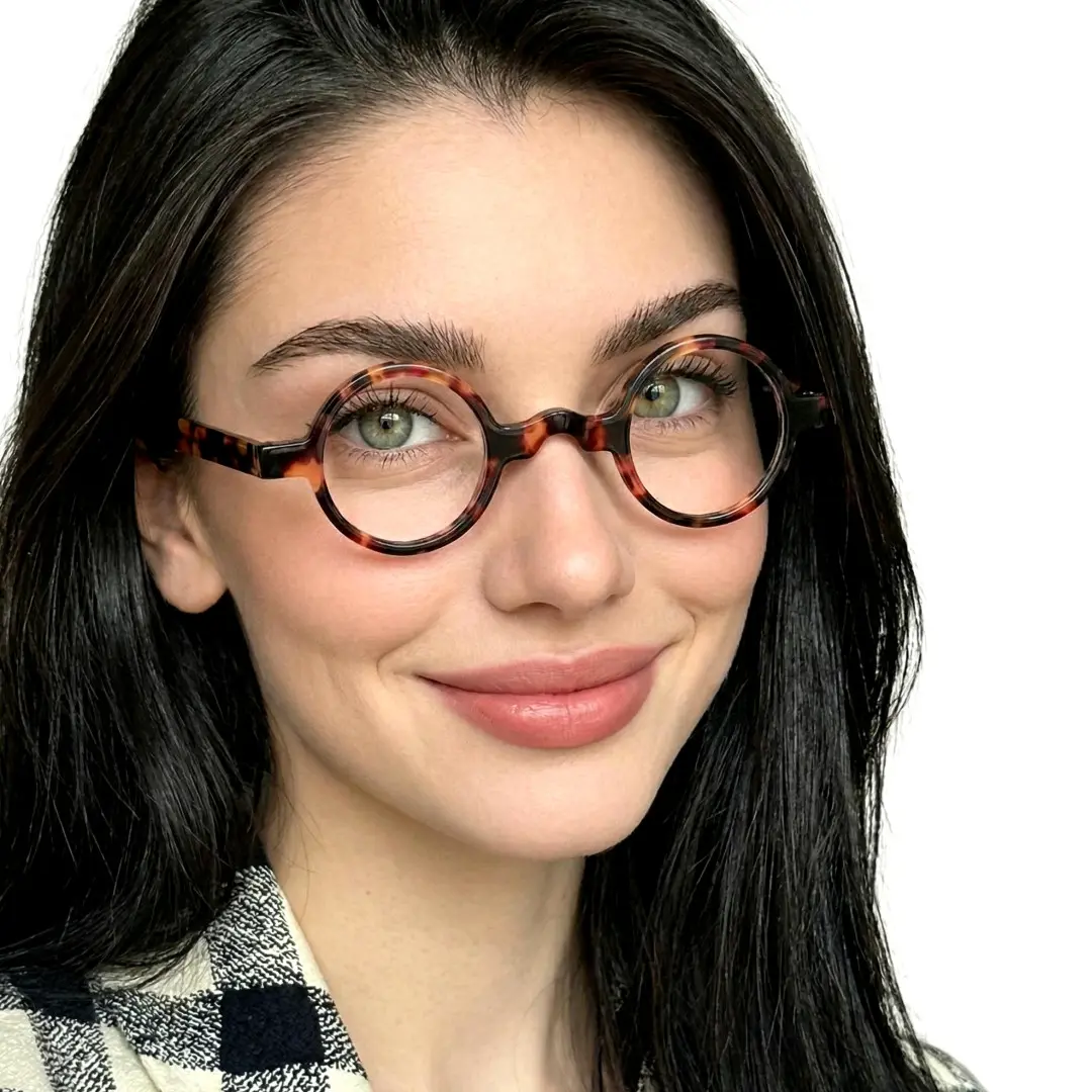 Slightly angled view of female wearing tortoise round eyeglasses, friendly smile, RA0332507