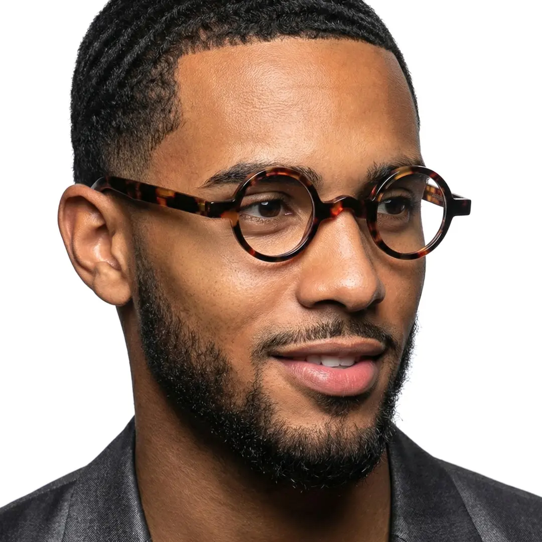Three-quarter view of male wearing vintage tortoise round eyeglasses, friendly smile, RA0332507