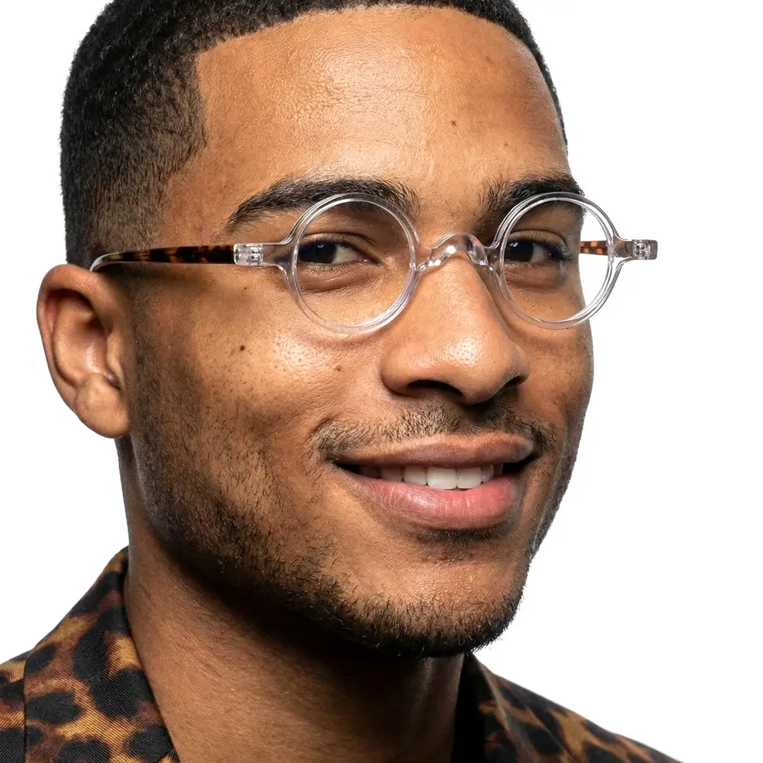 Three-quarter view of male wearing vintage clear round eyeglasses, natural smile, RA0402411