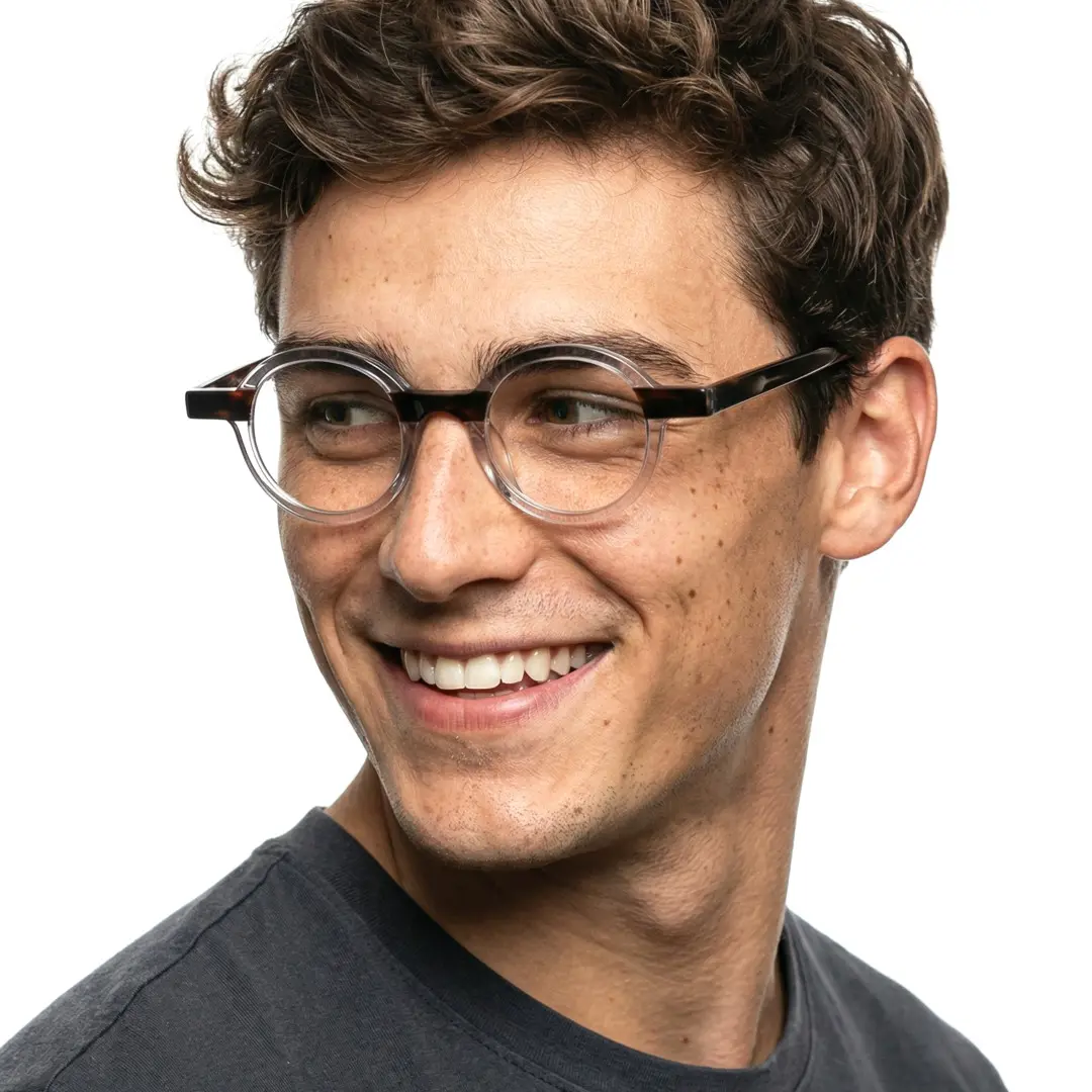 Looking away view of male wearing vintage clear round eyeglasses, smiling, RA0412302