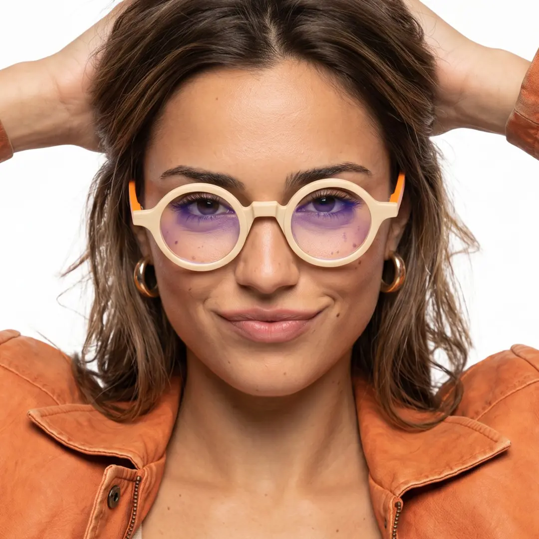 Close-up view of female wearing vintage beige round eyeglasses, hand in hair, soft smile, RA0572302