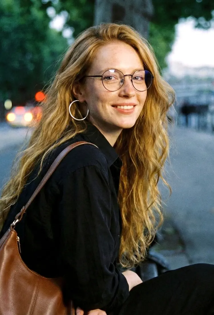 Female model wearing everyday black round metal eyeglasses on a city street with bokeh lights in the background. SPU: RM0082209