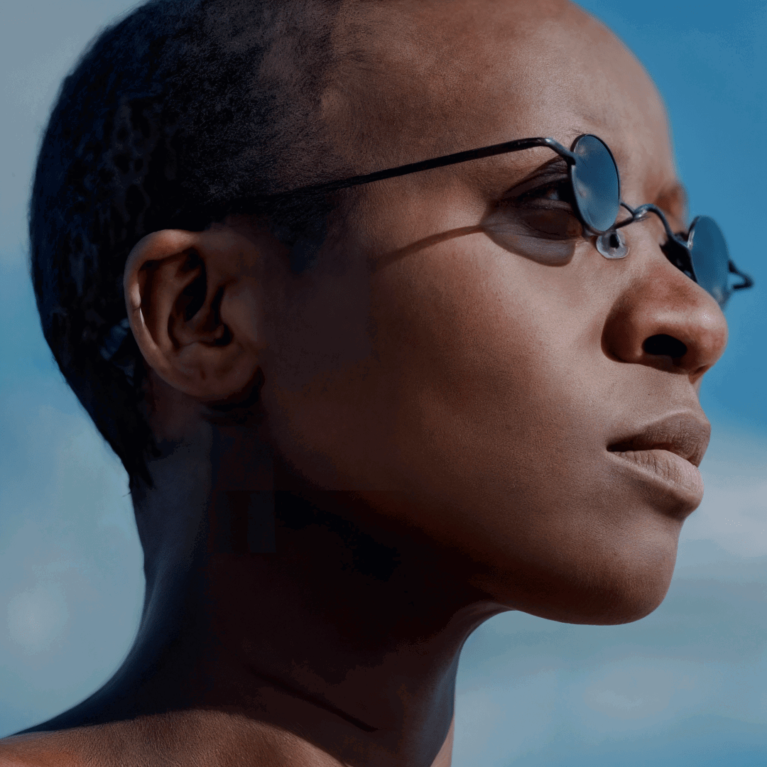 Profile view of female wearing black round eyeglasses, calm expression, RM0082308