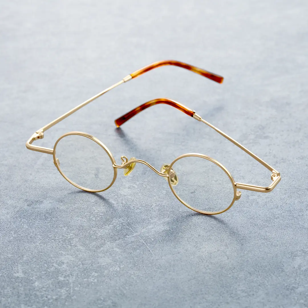 Scene close-up view of Yezy round metal eyeglasses RM0082308 in gold