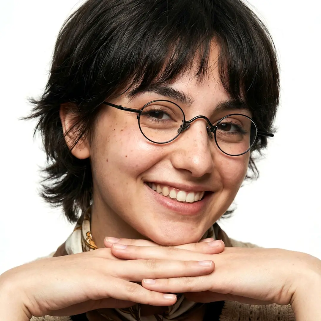 Front view of female wearing john lennon black round eyeglasses, resting chin on hand, smiling, RM0202601