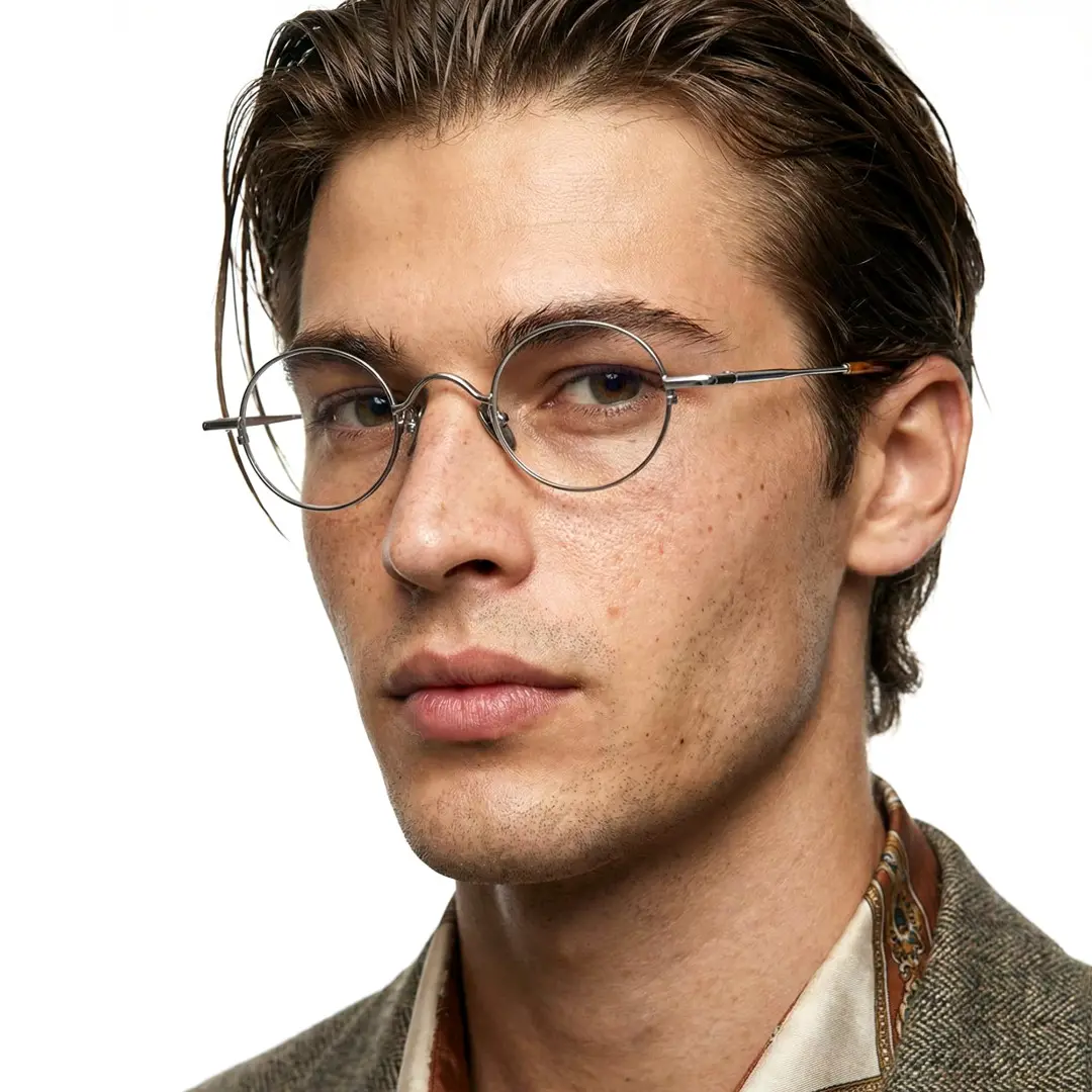 Three-quarter view of male wearing silver round eyeglasses, neutral expression, RM0202601