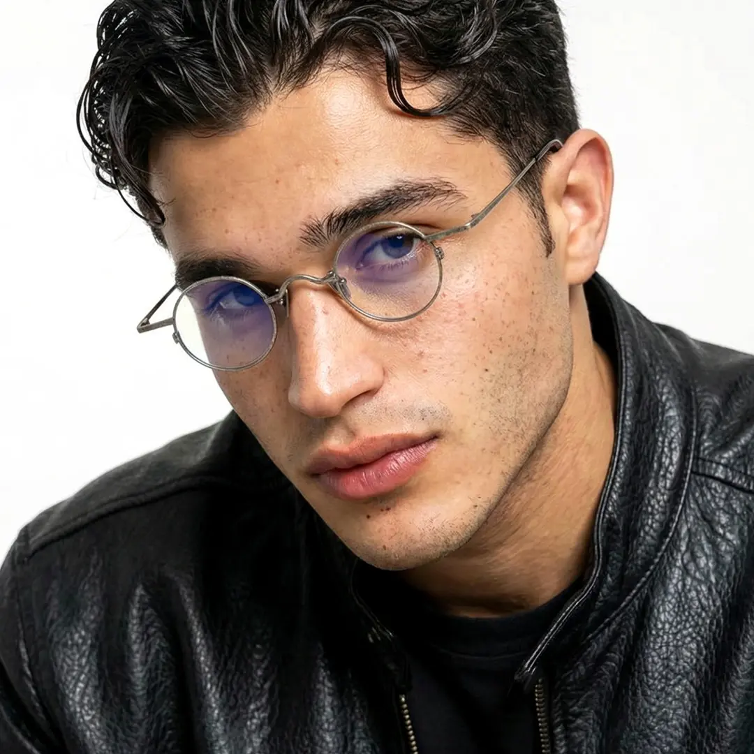 Slightly angled view of male wearing vintage silver round eyeglasses, natural expression, RM0242601