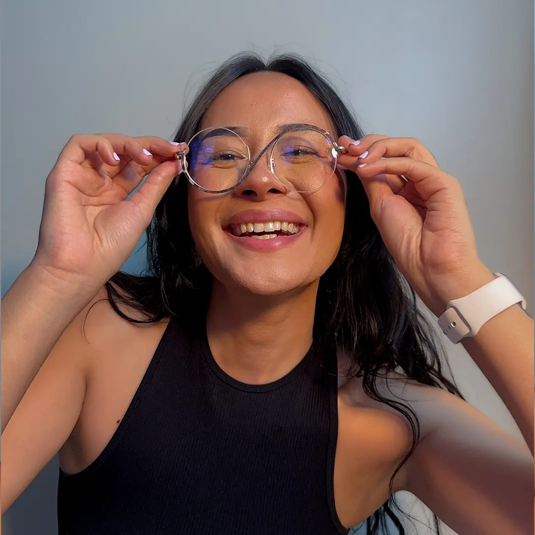 Portrait view of female wearing tortoise round eyeglasses, adjusting glasses, smiling, RM0332412