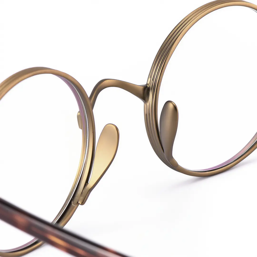 Integrated nose pad detail of Sam round metal eyeglasses RM0592302 in bronze