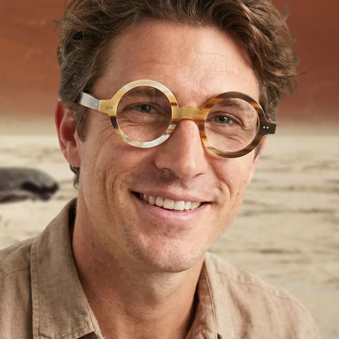 Three-quarter view of male wearing yellow round eyeglasses, smiling, RO0262511