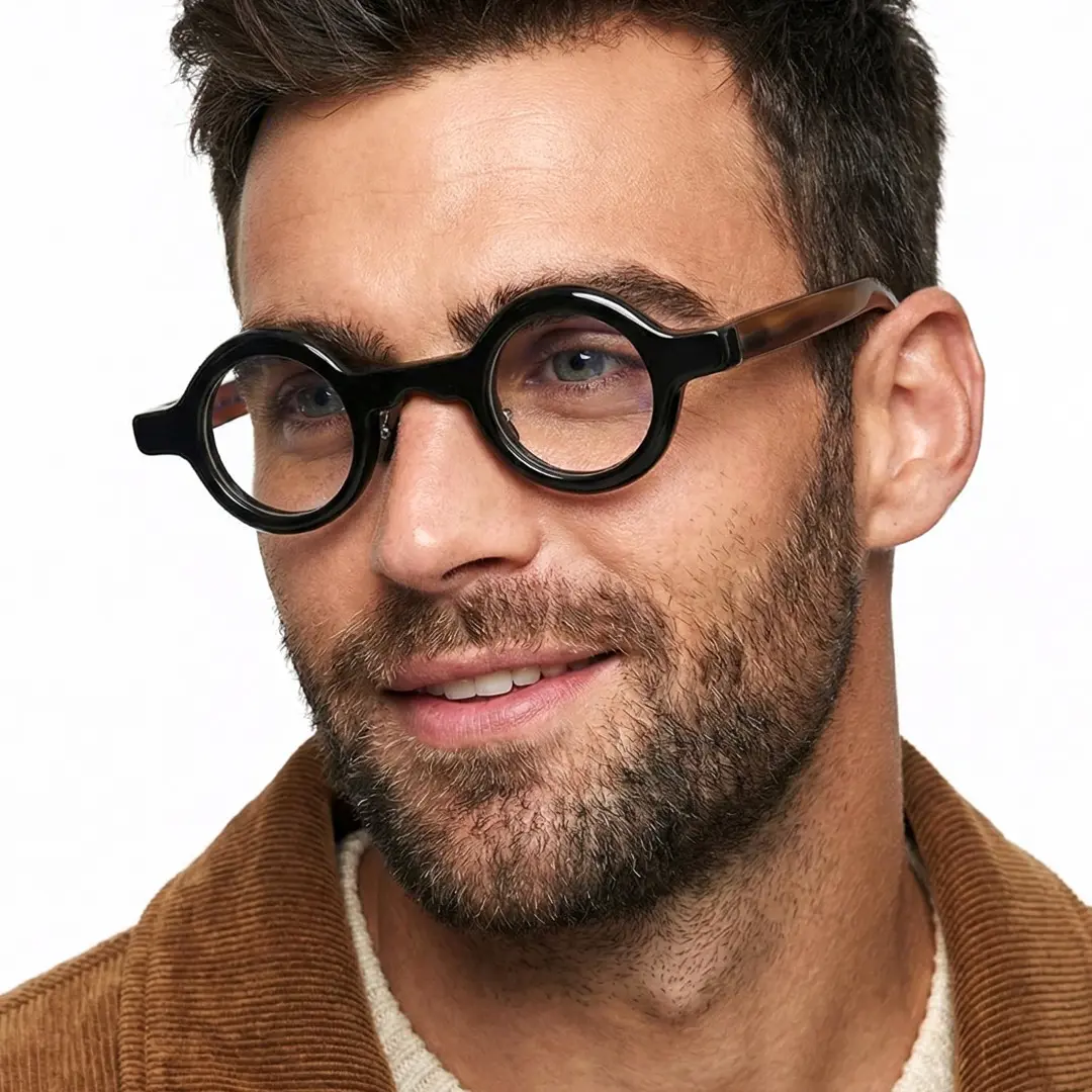Three-quarter view of male wearing black round eyeglasses, natural smile, RO0292511