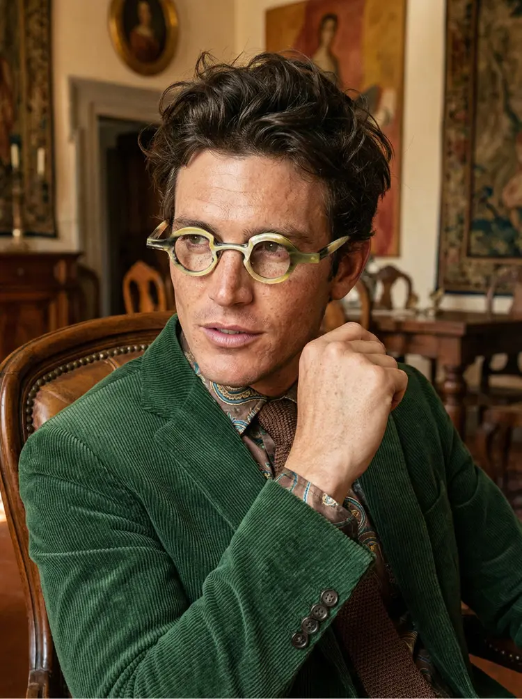 Male model wearing luxury white round natural ox horn handcrafted eyeglasses with a classic European city building background. SPU: RO0312511