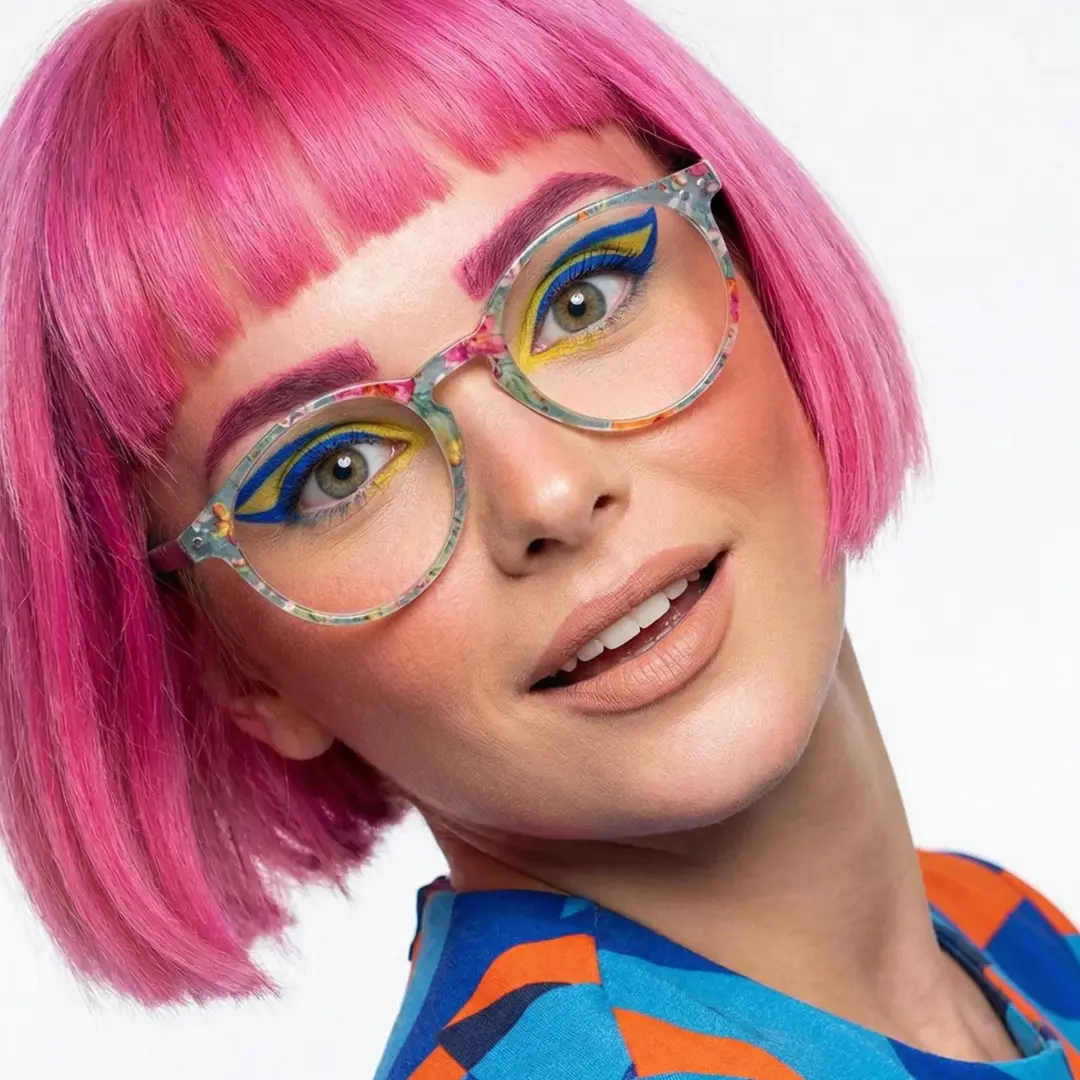 Over-the-shoulder view of female wearing colorful green round eyeglasses, smiling, RP0032308
