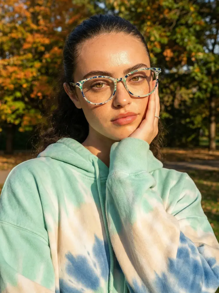 Female model wearing colorful blue round pc eyeglasses in a peaceful fall park. SPU: RP0212409