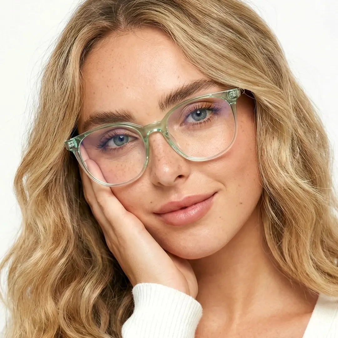 Slightly angled view of female wearing green round eyeglasses, hand near face, natural expression, RR0032408