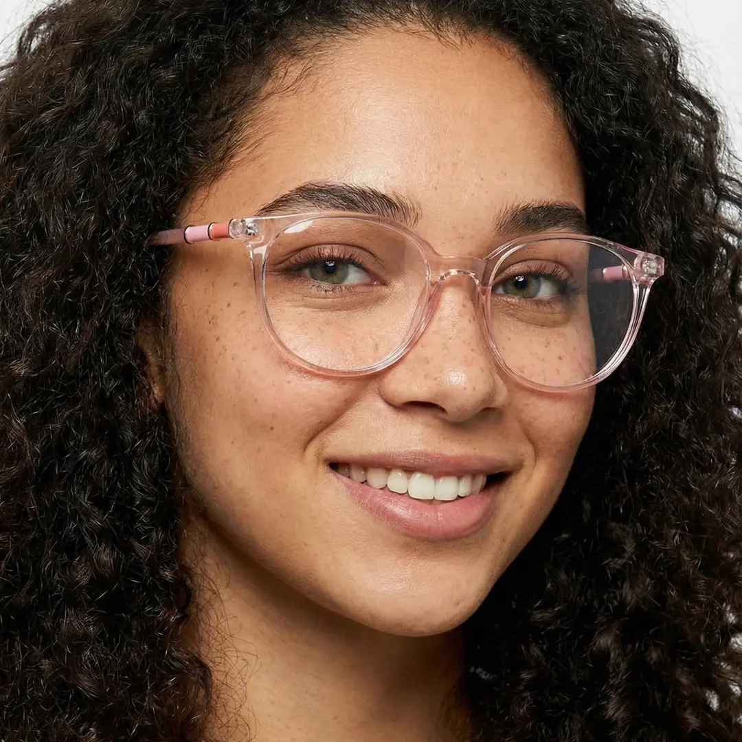 Face close-up view of female wearing pink round eyeglasses, smiling, RR0032408