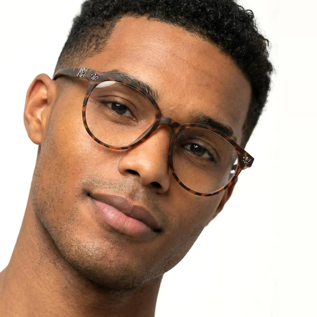 Tilted head view of male wearing tortoise round eyeglasses, neutral expression, RR0082409