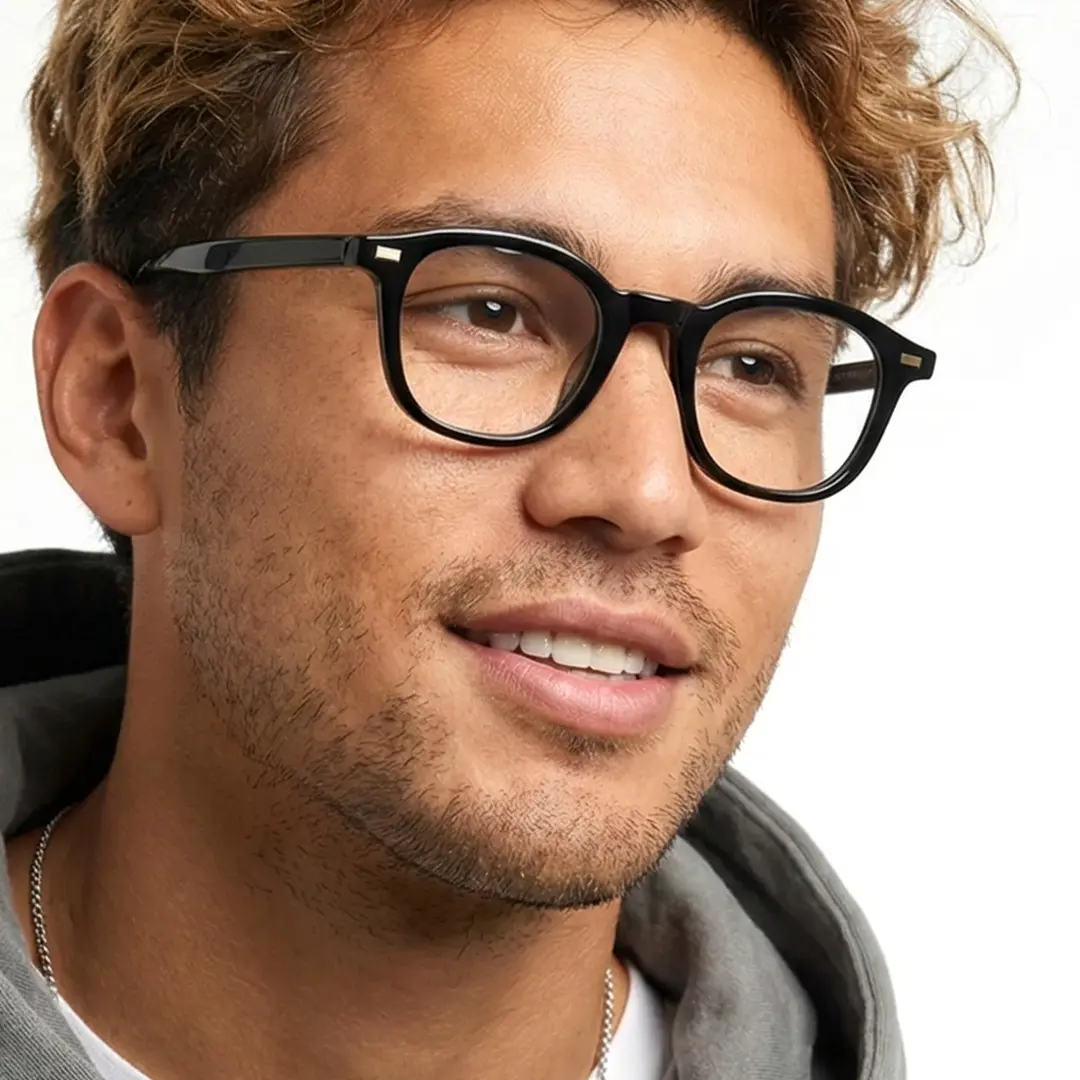 Three-quarter view of male wearing black round eyeglasses, natural smile, RR0082412