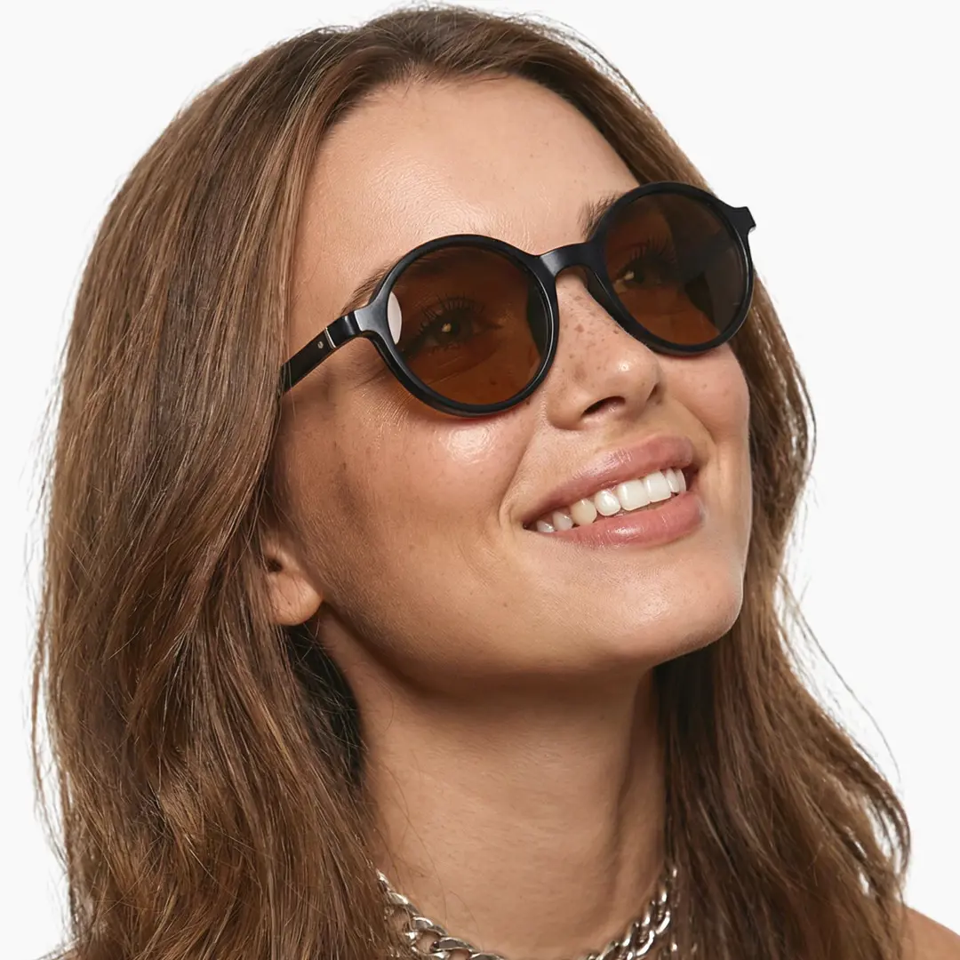 Slightly angled view of female wearing black round magnetic clip-on eyeglasses set with interchangeable clip-on lenses, smiling, RR0112601