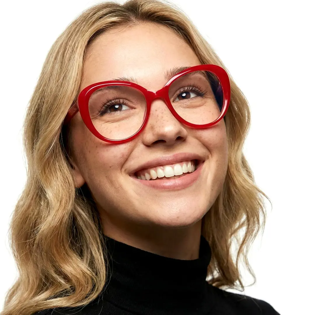 Three-quarter view of female wearing red round eyeglasses, smiling, RR0122502