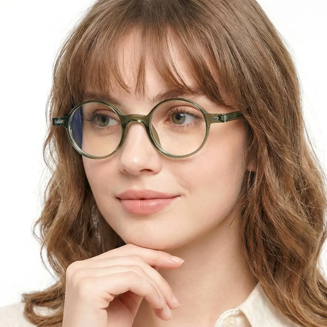 Front view of female wearing vintage army green round eyeglasses, resting chin on hand, soft smile, RR0162209