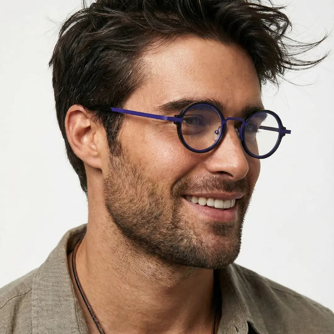 Profile view of male wearing blue round eyeglasses, smiling, RR0312406