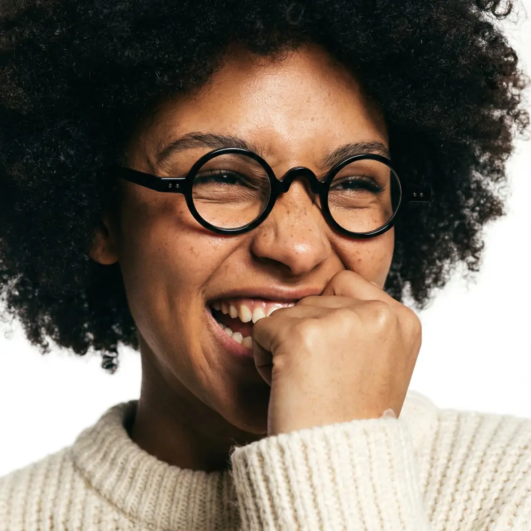 Three-quarter view of female wearing vintage black round eyeglasses, wide smile, RR0322601