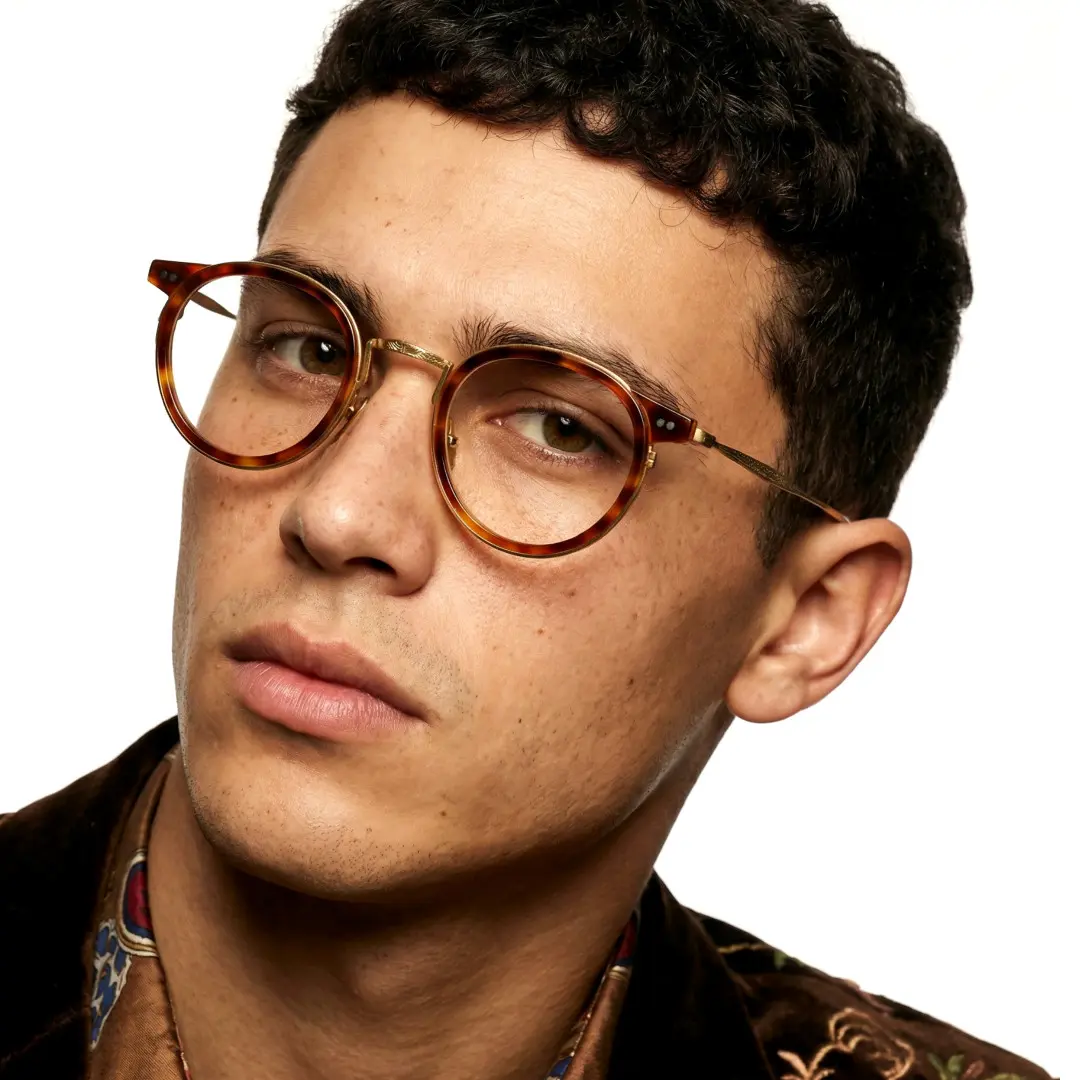 Tilted head view of male wearing yellow tortoise round eyeglasses, neutral expression, RT0022209